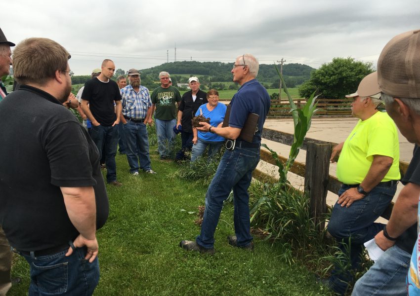 Group of people listening to a farmer speaking