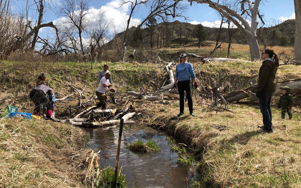 People installing a monitoring station in a creek