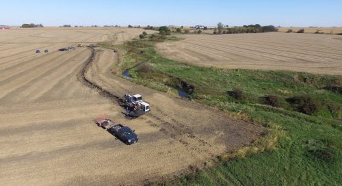 Aerial photo of trucks in farm field by saturated buffer