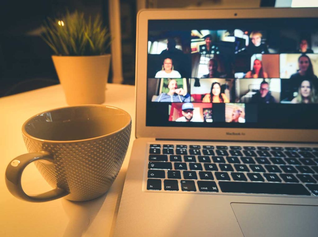 An open laptop computer with a virtual meeting on the screen